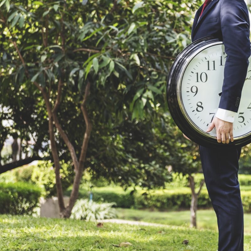 Personne tenant une horloge, illustrant le temps de formation nécessaire pour accéder aux métiers au Québec selon le système scolaire québécois.